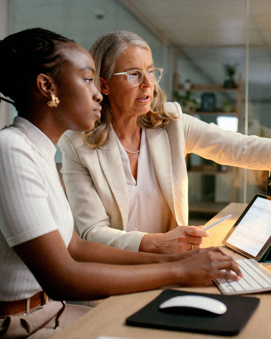 Two colleagues reviewing work at a desk