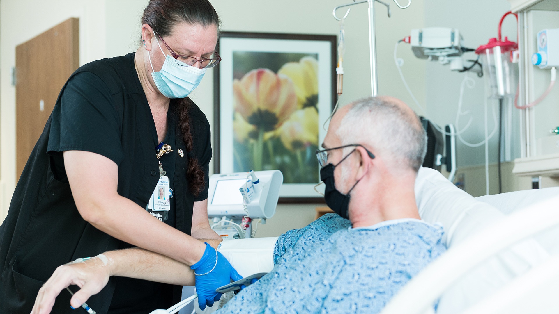 Nurse caring for a masked patient in a hospital room