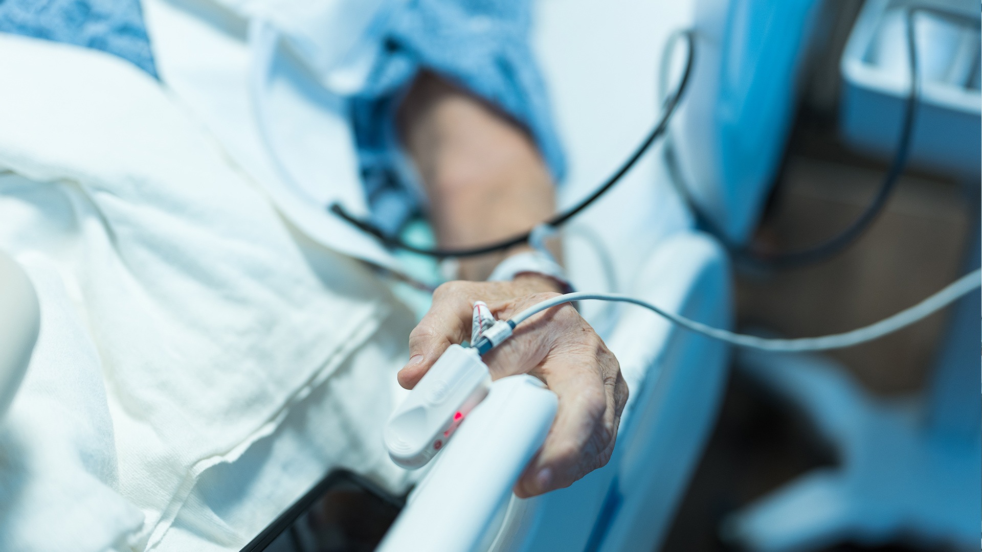 Close-up of a clinician's gloved hands adjusting medical equipment