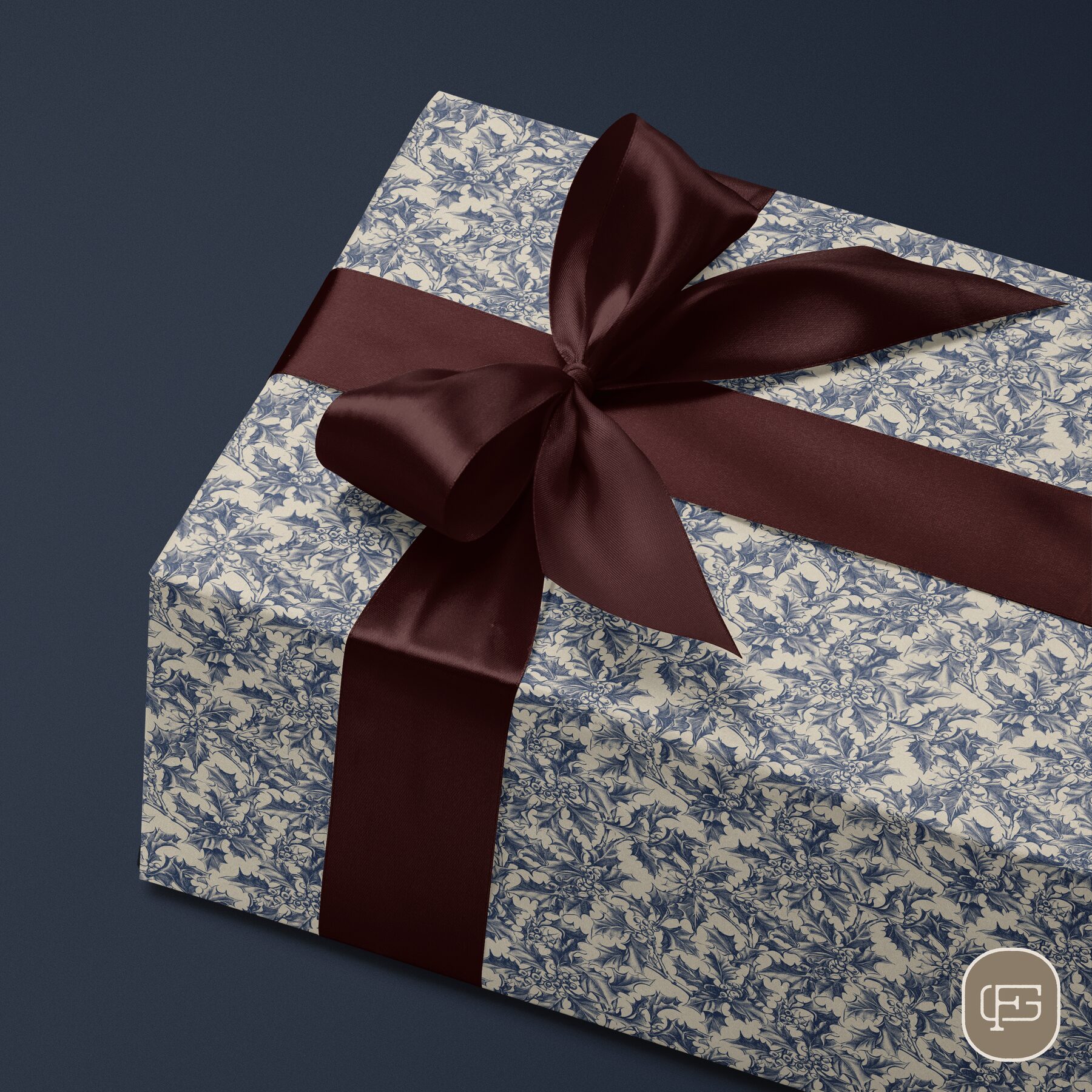Blue holly-pattern wrapping paper gift box with a burgundy ribbon